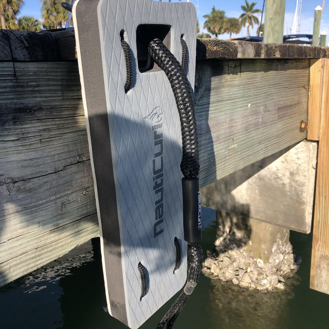 NautiFender flat boat fender by NautiCurl LLC mounted on a dock, protecting boat hull from contact with the dock surface.
