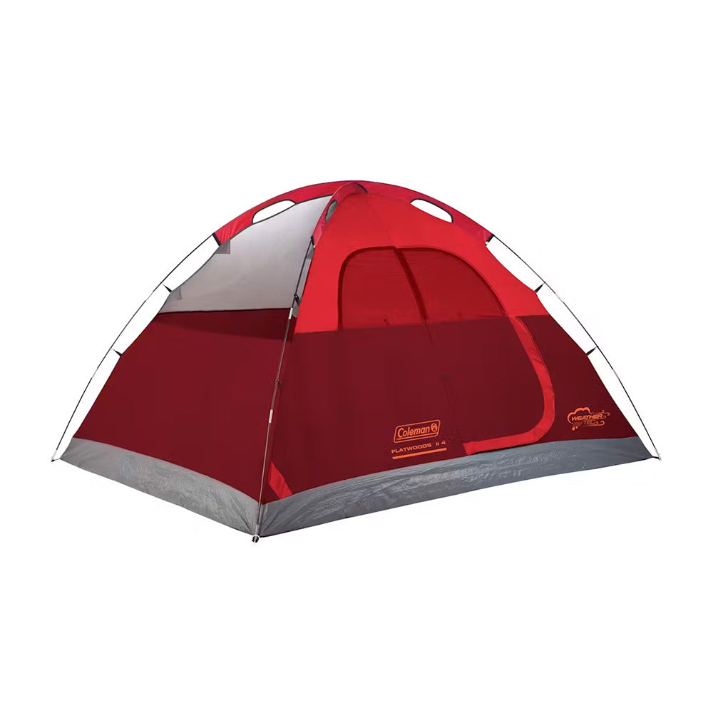 Red Coleman 4-person Flatwoods II lightweight dome camping tent set up outdoors, showcasing durable fabric and easy-setup design.