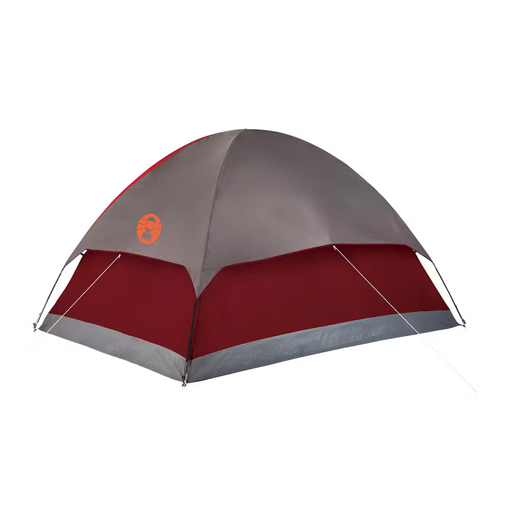 Red Coleman 4-person Flatwoods II lightweight dome camping tent set up outdoors, showcasing its compact, durable design.