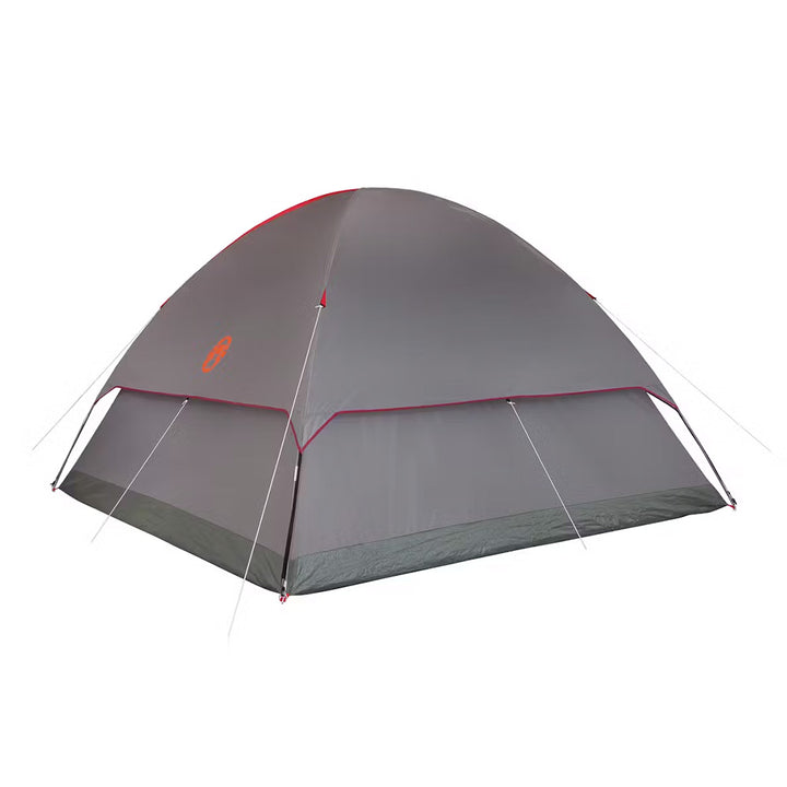 Red Coleman 6-person Flatwoods II lightweight dome camping tent set up outdoors with mesh windows and rainfly.