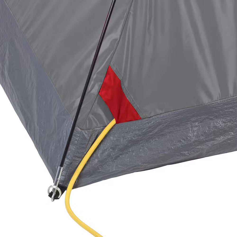 Red Coleman 6-person Flatwoods II lightweight dome camping tent set up outdoors, showcasing its durable fabric and spacious design.
