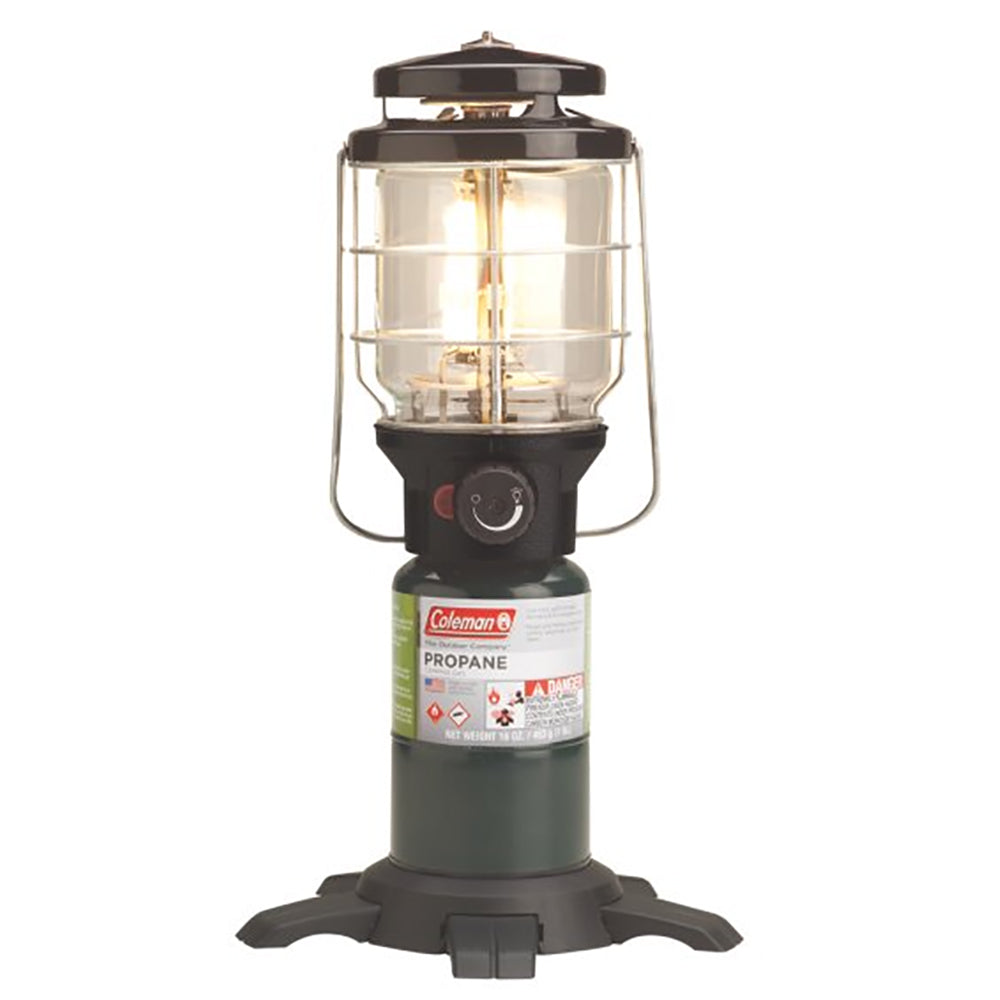 Coleman NorthStar propane lantern emitting bright 1500 lumens, green outdoor camping lantern with sturdy handle and glass globe.